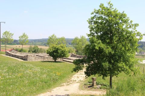 Römischer Gutshof "Villa Rustica". Zu sehen sind die konservierten und teilweise wieder aufgemauerten Nebengebäude des Gutshofes mit dem rekonstruierten Weihestein im Vordergrund