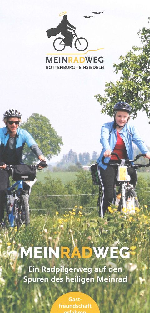 Titelblatt Flyer MeinRadweg. Ein junges Pärchen fährt mit dem Fahrrad durch eine grüne Wiese mit gelben Sumpfdotterblume. Oben ist das Logo ist der Schriftzug "Meinradweg" mit dem Logo zu sehen. Das Logo ist ein Mönch auf einem Fahrrad. 
