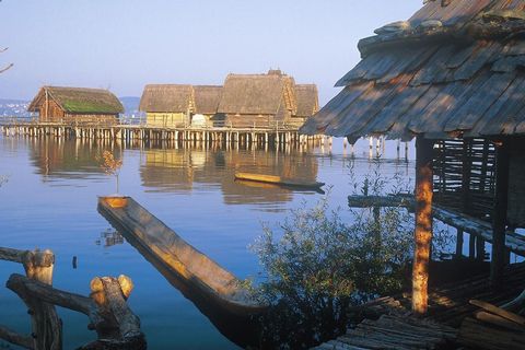 5 vorzeitliche Gebäude auf Stelzen im See im Museum Pfahlbauten Unteruhldingen (© Pfahlbaumuseum)